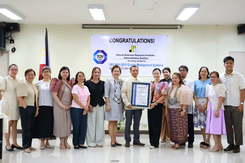 Estacio (center, with certificate) is flanked by Saloma (seventh from left) and Gunay (ninth from left), and joined by officials and staff from NSRI and TÜV SÜD PSB Philippines, Inc. Photo from NSRI Facebook page